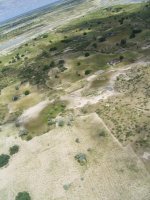 凧につけたカメラから撮影した、ナミビア北部の農村と季節河川です。写真の下のほうに畑や住居が広がり、奥に季節河川の川面がみえます。ナミビア北中部には季節河川が網の目状に分布しているため、村は中州状の高台に設けられます。撮影：藤岡悠一郎, 2005年3月 
